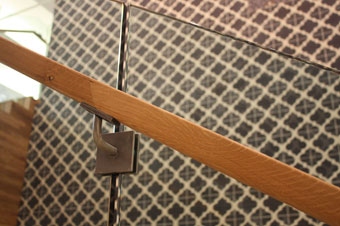 IMS developed handrail brackets that can be mounted at the seams between the sheets of glass.